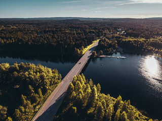 Bridge over water at Hyrynsalmi Finland with sunshine and some buildings