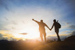 © Tinnakorn - Silhouette of hikers standing on top of hill and enjoying sunrise over the valley