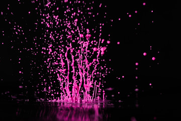 Wall Mural - Magenta, pink  paint, ink splash on black background