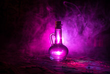 Antique And Vintage Glass Bottles On Dark Foggy Background With Light. Poison Or Magic Liquid Concept.
