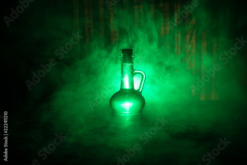 Cuadros en Lienzo Antique and vintage glass bottles on dark foggy background with light