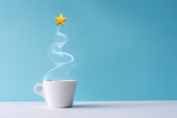 Wall Mural - Christmas tree made of steaming coffee or hot drink with yellow star cookie. Winter holiday concept. Minimal New Year background.