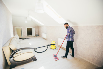 Young bearded man makes cleaning the house