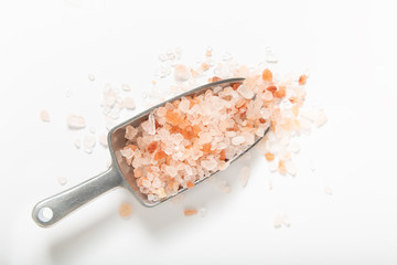 Healthy food concept pink Himalayan salt in iron scoop on white background