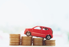 Little Red Car Over A Lot Of Money Stacked Coins With Background House. For Loans Costs Finance Concept. With Filter Tones Retro Vintage Effect ,Warm Tones.	