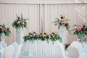 Wall Mural - Table set for wedding or another catered event dinner. Catering in restaurant for wedding party. Served tables with pink and red flowers. 