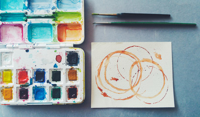 Palette of watercolor , with two brushes and spots of coffee