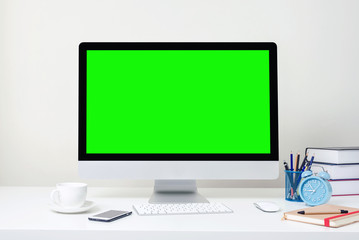 Design of workplace with computer green screen is standing on a desk in an office, Business Concept, copy space.
