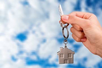 Poster - Hand Holding Metal House Key on white background