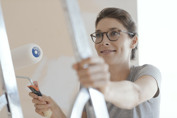 Wall Mural - Happy woman painting walls in her new apartment