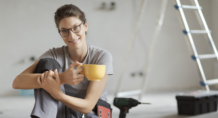 Wall Mural - Woman doing a home renovation and having a coffee break