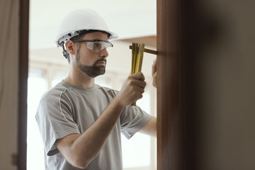 Wall Mural - Carpenter taking measures with a folding ruler