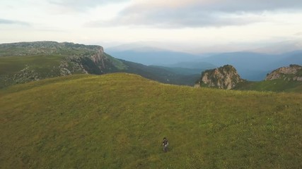 Wall Mural - aerial landscape from above flying drone people on green meadow in mountain
