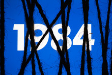 Smartphone In The Dark, Tightly Wrapped And Tied With Coarse Jute Rope Bondage With Glowing Blue Screen With White Text "1984". Concept Of Censorship On Social Networks. Totalitarianism. Dictatorship