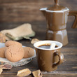 Cup of black coffee and almond cookies and fall leaves on wooden table. Delicious beverage for cold autumn season. Good morning concept.