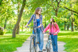 © Ermolaev Alexandr - Mom and daughter are cycling in the park together. Space for text