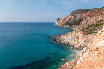  boat sailing along the coastline at Paliorema, Milos