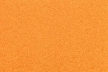 texture of old bright orange paper background, closeup. structure of dense carrot cardboard