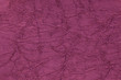 Dark purple wavy background from a textile material. Fabric with fold texture closeup.