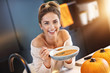 © Kalim - Adult woman eating pumpkin soup in the kitchen