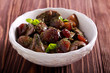 Chicken liver with plums in a bowl