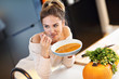 © Kalim - Adult woman eating pumpkin soup in the kitchen