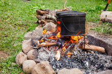 Cooking Camp Food In Cauldrons On Open Fire