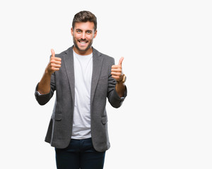 Young handsome business man over isolated background success sign doing positive gesture with hand, thumbs up smiling and happy. Looking at the camera with cheerful expression, winner gesture.