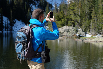 Wall Mural - Backpacker taking photo with smartphone