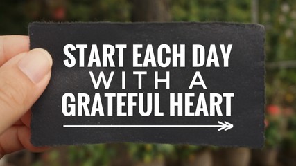 Wall Mural - Motivational and inspirational quote - ‘Start each day with a grateful heart’ written on a paper. Vintage styled background.