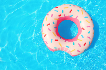 Wall Mural - Inflatable ring floating in swimming pool on sunny day, top view with space for text
