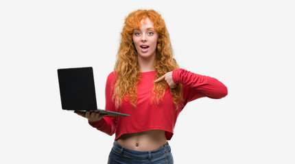 Canvas Print - Young redhead woman using computer laptop with surprise face pointing finger to himself