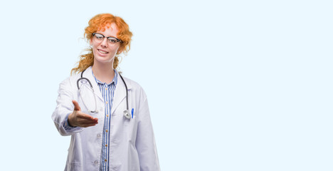 Poster - Young redhead woman wearing doctor uniform smiling friendly offering handshake as greeting and welcoming. Successful business.