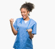 © Krakenimages.com - Young afro american doctor woman over isolated background very happy and excited doing winner gesture with arms raised, smiling and screaming for success. Celebration concept.