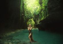 Young And Sexy Nymph Is Walking In The Canyon. Staying In The Sun Lights. Playing With Turquoise Water. Wearig A Long Green Dress. Wet. Art Photo. Backgroud. Journey. Georgia. Martvili. Travelling.
