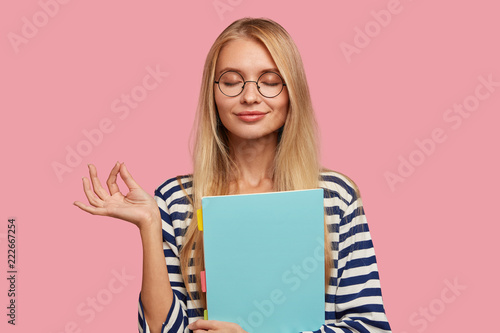 Fotomural Photo of pleasant looking pleased blonde woman makes okay gesture, believes in s
