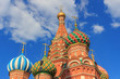 Onion domes of St. Basil's Cathedral on Red square in Moscow on a blue sky with white clouds background at sunny summer evening