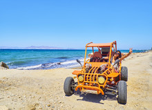 A Happy Girl Driving A Buggy On A Dune Of Beach With The Aegean Sea In Background. Greek Island Of Kos. South Aegean Region, Greece.