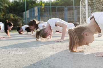 Wall Mural - Group of young woman doing push-ups