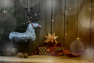 Wall Mural - Christmas background / toy wooden deer ,gifts,star  and cones on the old wooden table