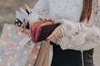 Woman with shopping bags holding a leather wallet. Concept of epmty purse after black friday sale