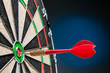 Close-up view of a red dart on the bullseye of a dartboard