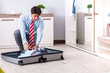 © Elnur - Young handsome businessman preparing for trip