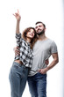 © ASDF - oung couple looking up and pointing upwards