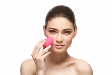 Wall Mural - girl with makeup sponge isolated on white