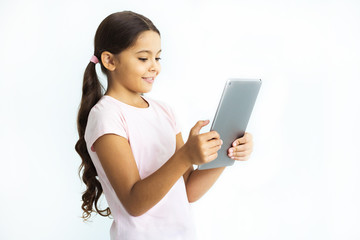 Wall Mural - The happy girl holding the tablet on the white wall background