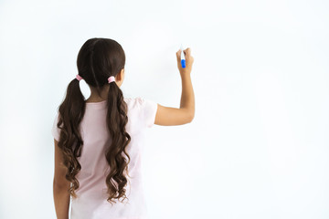 Wall Mural - The little girl writing on the white wall