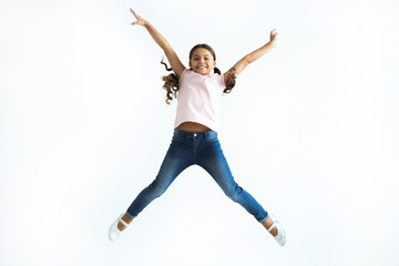 Wall Mural - The little girl jumping on the white wall background