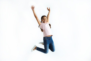 the little girl jumping on the white wall background