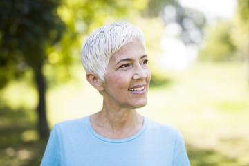 Wall Mural - Portrait of a smiling sporty senior woman in a park